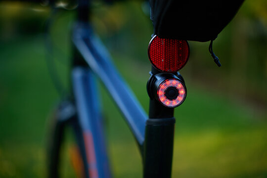 Close-up of a red rear light and reflector on a bicycle