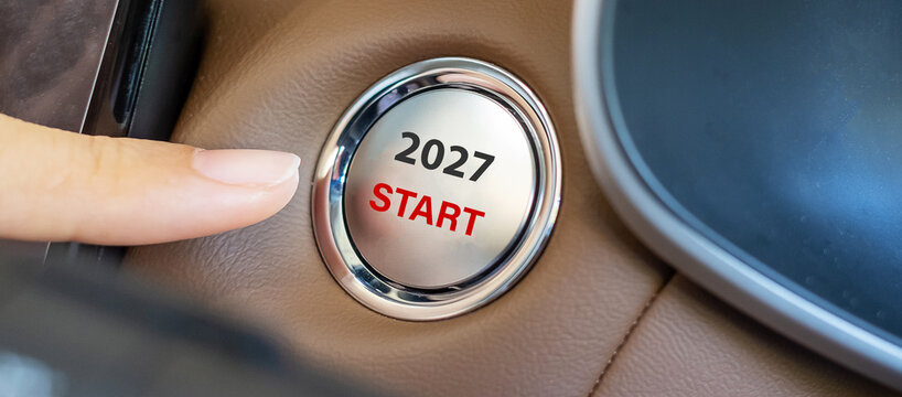 Finger press a car ignition button with 2027 START text inside  automobile. New Year New You, forecast, resolution, motivation, change, goal, vision, innovation and planning concept
