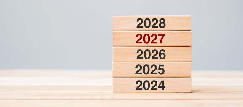 2028 block over 2027 and 2026 wooden building on table background. Business planning, Risk Management, Resolution, strategy, solution, goal, New Year New You and happy holiday concepts