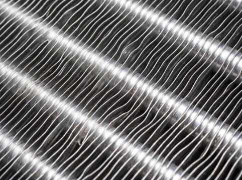 Macro close up view of aluminum fins and metallic tubes on a radiator heat exchanger core