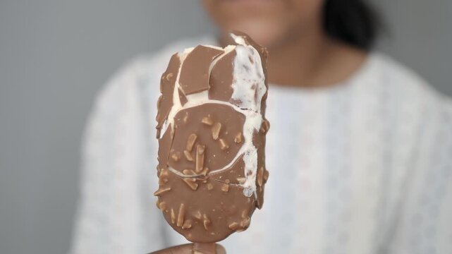Enjoying a chocolate ice cream bar with nuts on a warm day