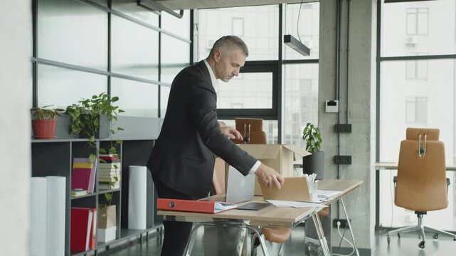 Taking box with personal stuff from office. Man by dismissal. Guy lost job. Fired manager in company. Dismissal box of employee. Man office worker disappointed by dismissal. Fired business man office