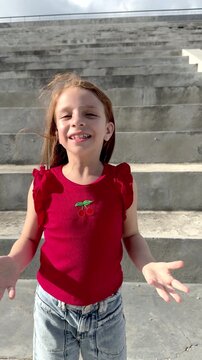 Happy redhead girl filming herself dancing for social media outdoor - Kid influencer and content creation concept - Vertical video