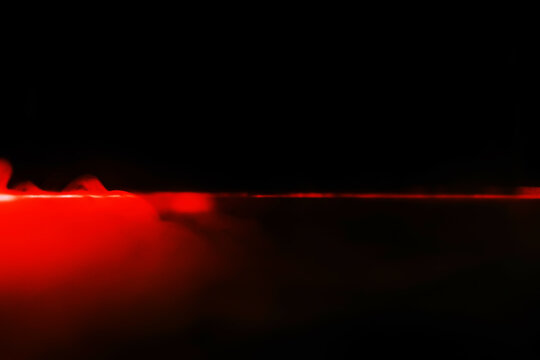Red smoke over black studio background. Red steam on a black background. Copy space.