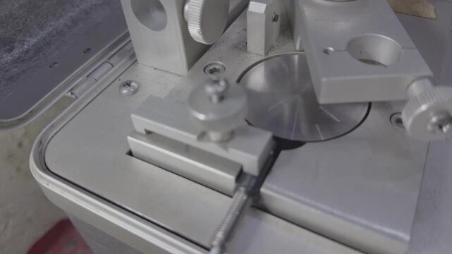 Slow motion close-up of a speed sensor mounted on a test device while the rotating shaft is spinning for industrial instrumentation testing.