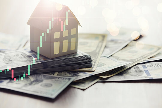 House model and Money, house key lying on real estate contract, home loan and investment concept.