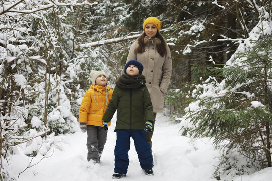 Happy family playing and laughing in winter outdoors in the snow. City park winter day.