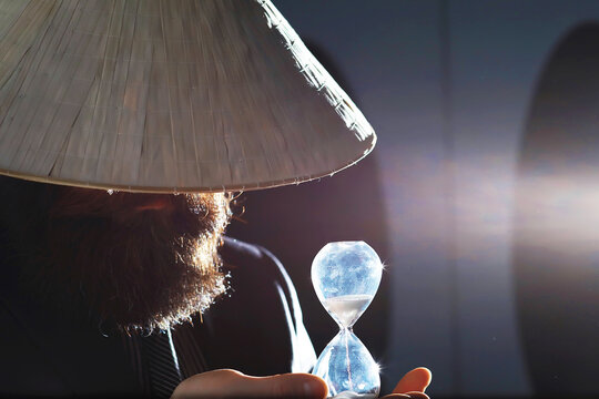 A bearded man in a suit holds an object in his hand. Concept of time and ideas. Aspiration and development.