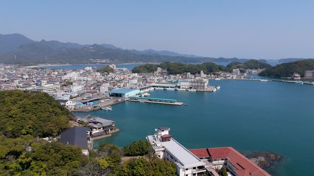 Aerial drone footage showing a high angle view of a regional tuna market wholesale building and harbor dock facilities. Captures the commercial fishing trade infrastructure highlighting themes of glob