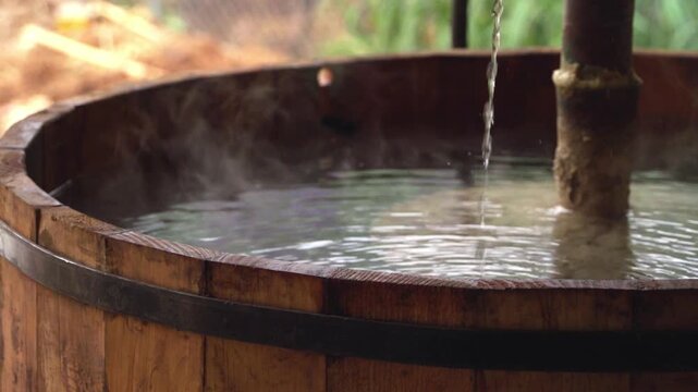 Wide establishing shot of a traditional Mexican large rustic wooden vats used for agave fermentation inside an authentic artisanal mezcal distillery