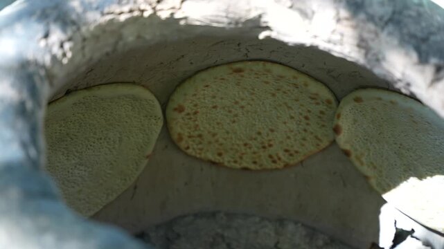 Traditional Turkmen flatbread baking in a clay oven, Central Asia food