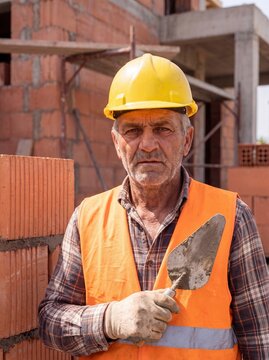professional worker using masonry trowel and cement mortar during construction