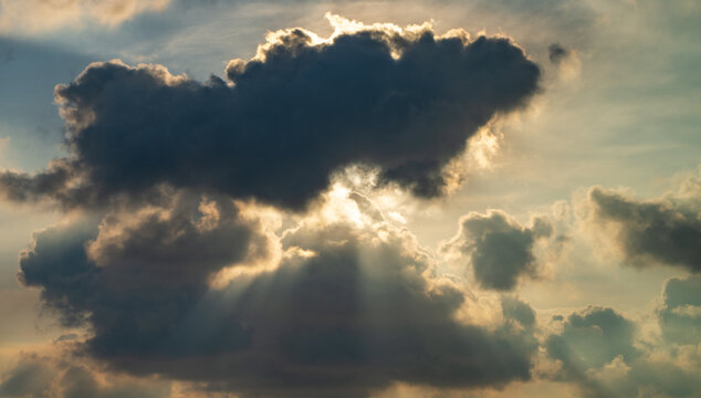 Bright sun rays stream through the cloud formations