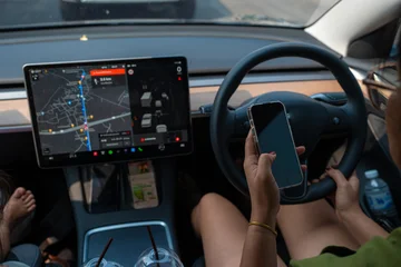 Woman drive EV car use smartphone in city with GPS navigator © themorningglory