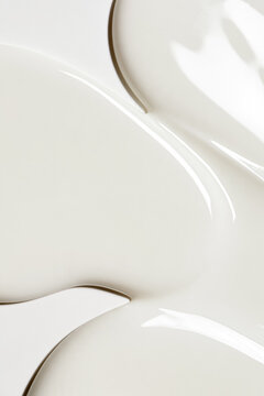 Smooth white liquid texture with elegant waves and ripples, showing movement and fluidity for cosmetic products or creamy food