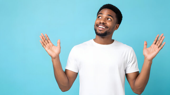 Happy young African American man looking up with open arms.