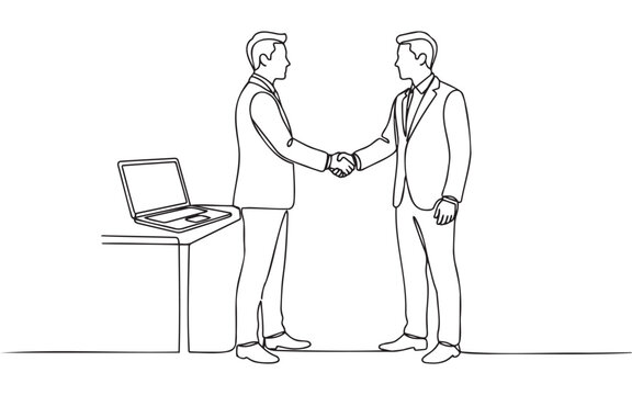 Two business men in suits shaking hands after a professional meeting with a laptop computer on an office desk