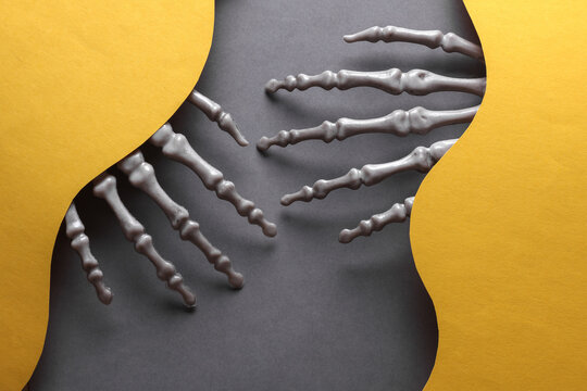 Skeleton hands on a wavy layered background. Halloween concept. Trick or treat. Creative layout