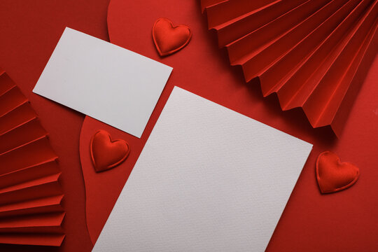 Chinese New Year background. White blank cards, hearts and Asian traditional paper fans and wavy red layers. Creative layout.