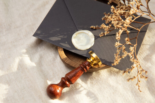 Envelope and a vintage stamp on a linen background with natural sunlight. Wedding invitations, stationery.