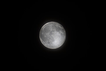 Nearly full Moon with visible craters against a black sky © Xiaohan