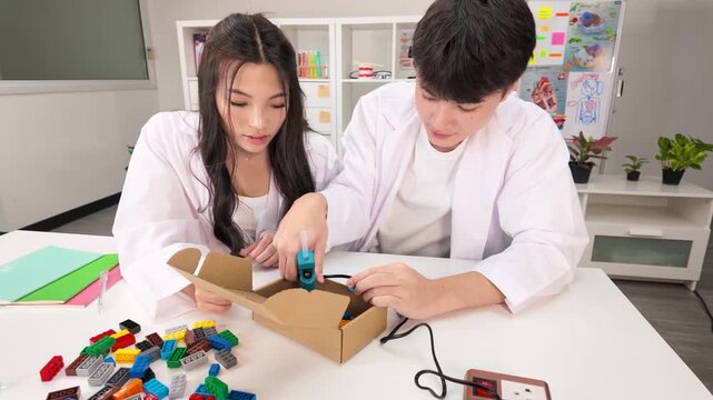 Teen Students in Lab Coats Collaborating on STEM Craft Project