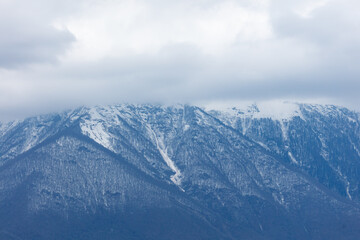 Obraz premium Snow-capped mountains rise beneath a cloudy sky