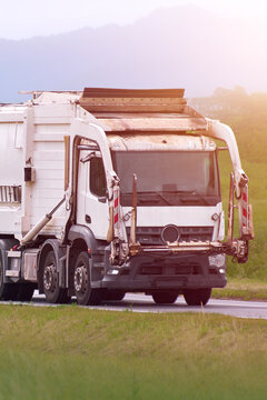 Waste management vehicle operating on a quiet country road