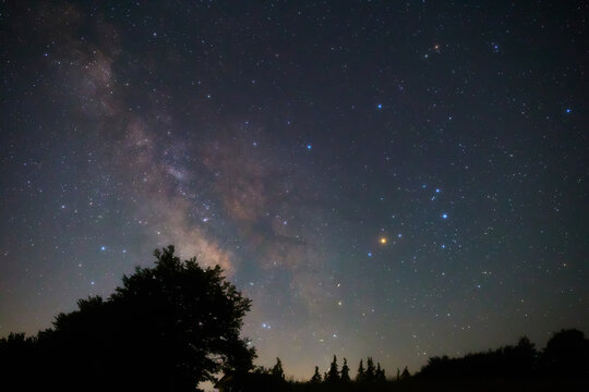 Summer Milky Way stars and landscape scenery silhouettes.