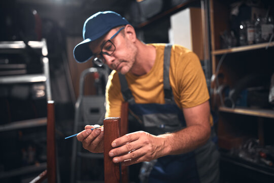 Man working in a workshop for furniture repairing and restoration.
