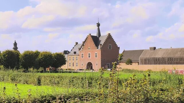 Herkenrode Abbey in Belgium captured from a distance with surrounding fields and trees