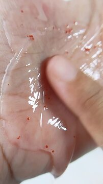 Point of view of spreading clear cleansing gel evenly on palm skin using index finger. Skincare application concept for daily beauty routine.