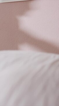 Soft shadows move across pink textured wall creating abstract shapes and patterns with no visible human subjects or objects. scene remains static except for gradual shift in shadow positions