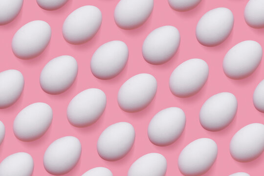 Natural white chicken eggs with soft shadow as minimal style pattern on pink background. Top view still life photo, creative food layout, egg day holiday concept, graphic flat lay pastel colored.