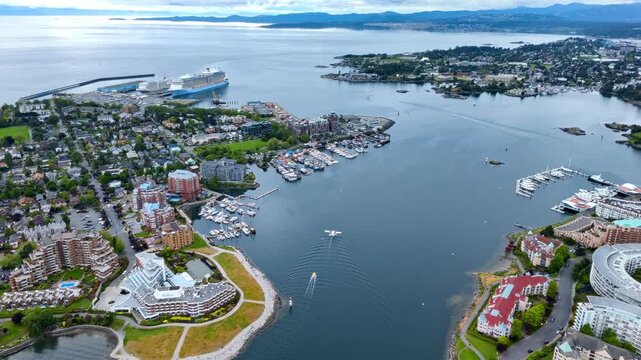 Scenic aerial panorama of Victoria Inner Harbour, British Columbia, overlooking coastal residential bays, private marinas, and distant ocean cruise docks.