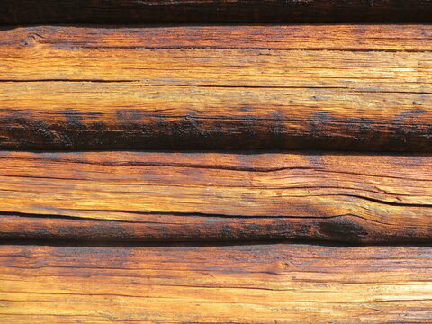Full frame background texture of weathered wooden logs with natural grain cracks and horizontal lines