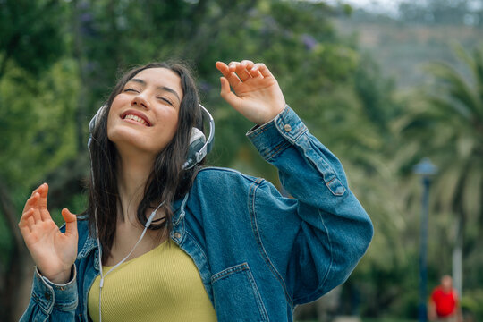 Young woman listening music while walking in the street. Travel, tourism, technology, blogging concept