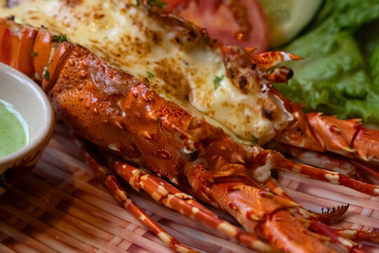 Deliciously Grilled Lobster Tail Garnished with Fresh Vegetables and Vibrant Herb Sauce for an Exquisite Dining Experience