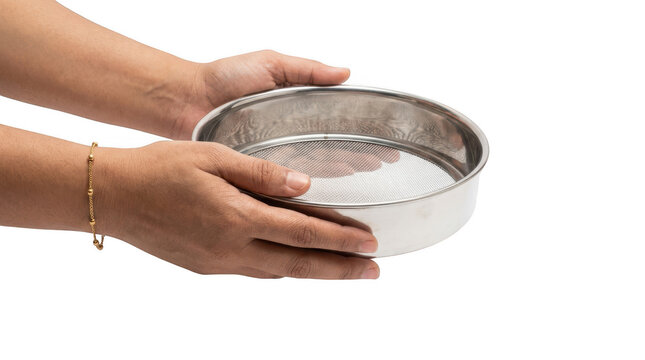 Person holding a round stainless steel kitchen sieve for sifting flour and ingredients in the kitchen while preparing homemade food and healthy cooking recipes