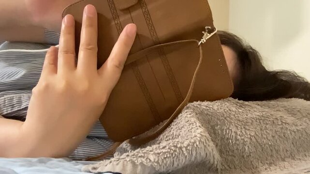 寝ながらスマホ操作する女性