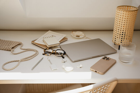 Aesthetic Neutral Workspace Table Setup With Rattan Lamp And Glasses