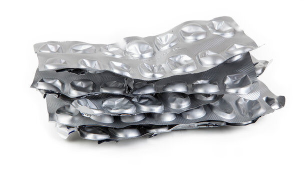 Used and empty aluminum blister packs for tablets and medications. Medical waste. Concept of empty packaging on a white background. Aluminum and plastic recycling.