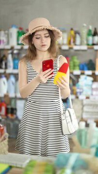 Girl buyer scans qr code on mosquito repellent label, uses link to get additional information on Internet. Customer photographs product, searches for photo on Internet 