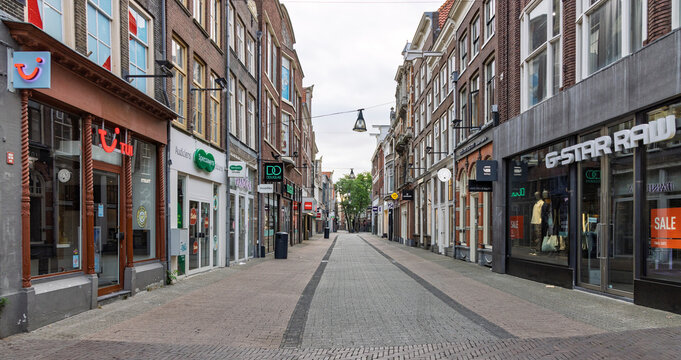 Zwolle, Netherlands - 23 August 2026 - Empty shopping street Diezerstraat with brand store fronts and historic buildings during quiet morning in Zwolle city center.