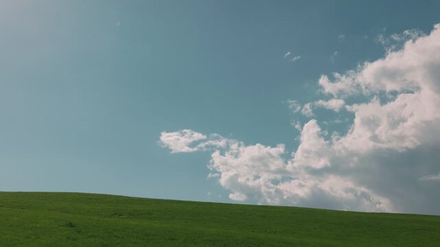 Gentle Sloping Grassland Under a Blue Sky with Clouds