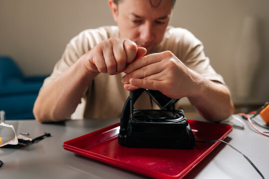 Skilled technician performing maintenance and installation on sophisticated cooling system for computer cpu, ensuring efficient heat dissipation and enhanced system stability at workshop.