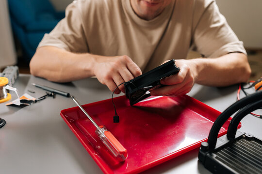 Cropped shot of unrecognizable technician cleaning and maintaining computer liquid cooling system components, ensuring optimal performance and extending hardware lifespan for efficient computing.