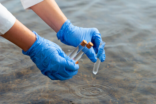 scientist gloved hands collecting water sample test tubes lake river surface microplastic pollution testing environmental research concept of ecology contamination science