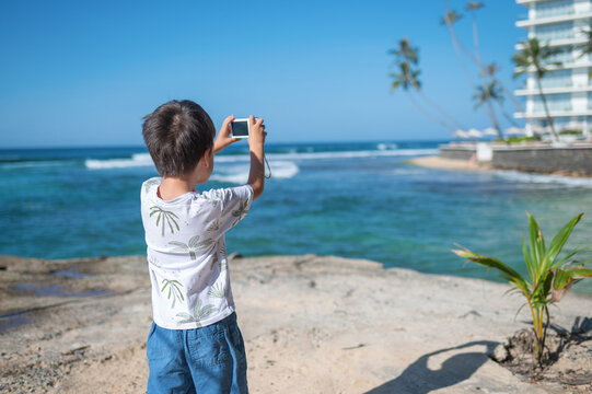 Child capturing memories on smartphone at tropical island getaway