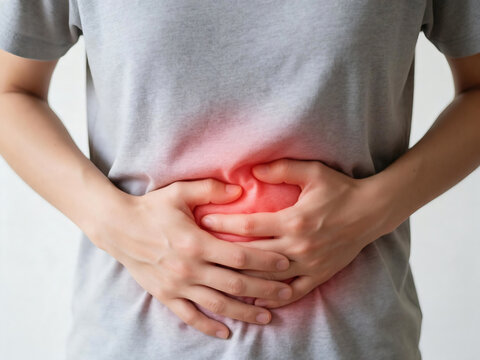 Close Up Of A Person Wearing A Grey T Shirt Holding Their Stomach In Pain With A Red Glowing Highlight Indicating Abdominal Discomfort